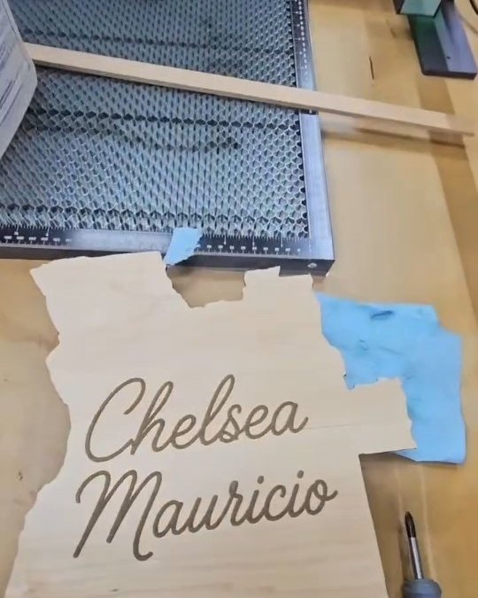 Cut wooden name sign in progress on the workbench